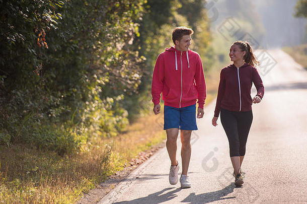这对年轻夫妇一边沿着乡间小路慢跑，一边享受着健康的生活方式、锻炼和健身理念