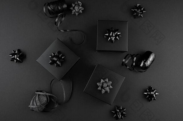 极简主义的黑色平铺。黑色表面有丝带的黑色礼品盒，黑色星期五概念，送给男人、父亲、丈夫的礼物。