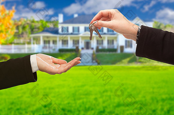 房地产经纪人在一座漂亮的新房前交出房屋钥匙。