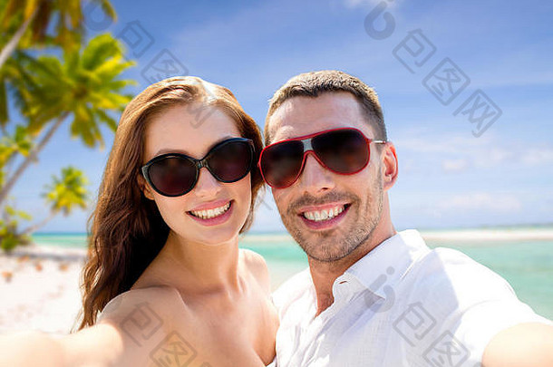 一对戴着太阳镜的<strong>情侣</strong>在海滩上自拍