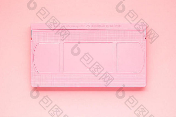 粉红色背景上彩绘VHS磁带的创意照片。