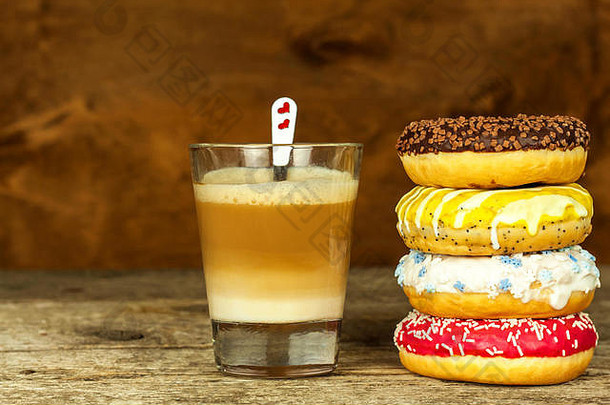 不健康的食物。木制桌子上的甜甜圈。咖啡加甜点。肥胖和糖尿病的危险。糖果的销售。早餐吃甜甜圈。