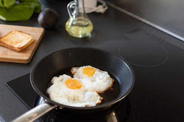 在家庭厨房的<strong>现代感</strong>应炉上准备清晨鸡蛋早餐。