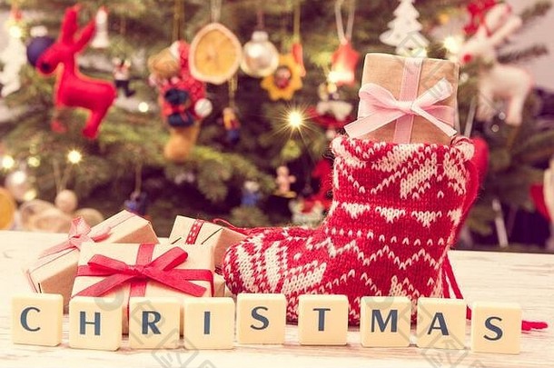 复古照片、圣诞彩带礼物、圣诞树背景上的节日羊毛袜、灯光和装饰、圣诞节时间概念
