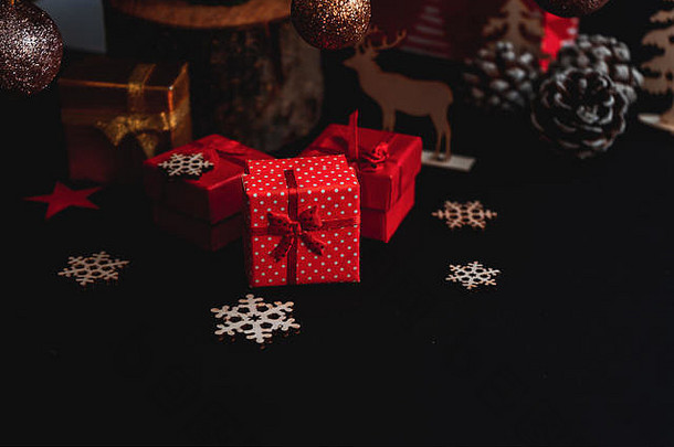 树下的红色小礼盒，黑色背景，圣诞装饰，圣诞礼物，社交媒体的圣诞图片，文本的空白空间