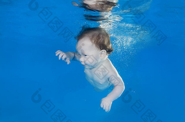 5个月大的在游泳池里的水下游泳课上学习水下游泳