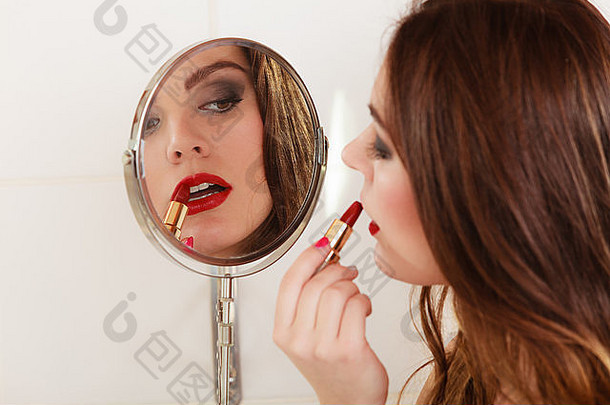 年轻的女孩使化妆浴室女人护理镜子