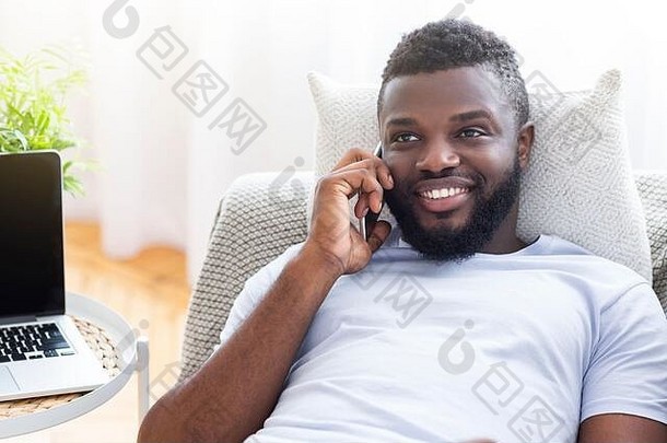 在家里用手机交谈的微笑的非裔美国人