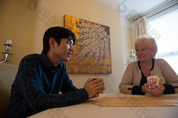 一名年轻的亚洲<strong>留学</strong>生在他的学生宿舍与他的英语主人放松
