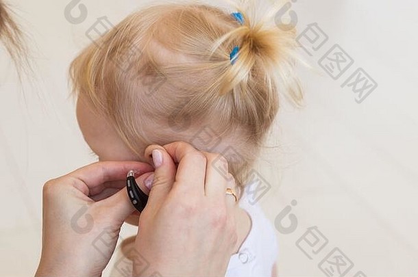 耳朵里的助听器。蹒跚学步的孩子在家里戴着助听器。残疾儿童、残疾和耳聋概念。