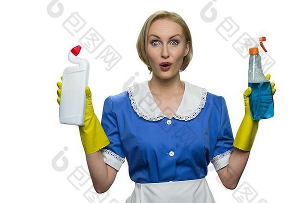 惊讶的女佣拿着白色背景上的清洁剂喷雾和厕所消毒液。