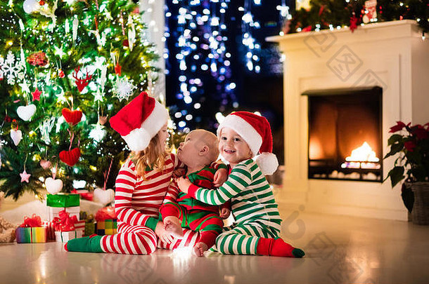快乐孩子们匹配红色的绿色条纹睡衣装修圣诞节树美丽的生活房间火的地方