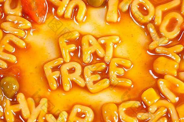 字母形状的意大利面形成单词脂肪免费的番茄酱汁