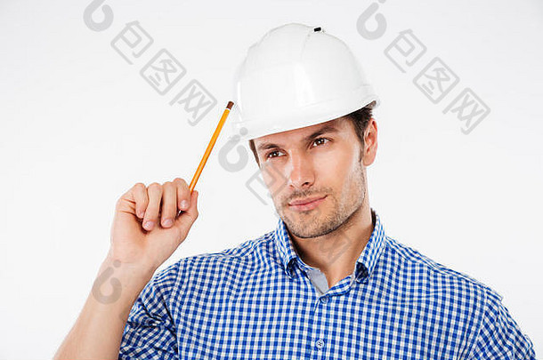 有思想的年轻建筑工人用铅笔思考建筑头盔