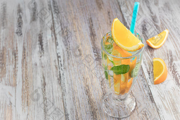 木制桌子上的玻璃高脚杯中的柑橘<strong>清凉</strong>饮料。<strong>夏日</strong>清爽鸡尾酒。健康食品、饮料。橘子和薄荷冰水。拷贝空间