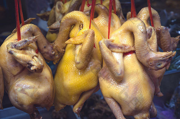 泰国曼谷的一个街市上挂着许多鸡的尸体
