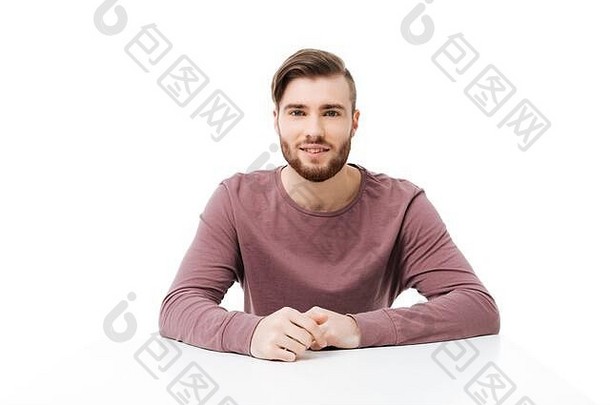 英俊、年轻、友好的男子看着坐在桌旁的摄像机