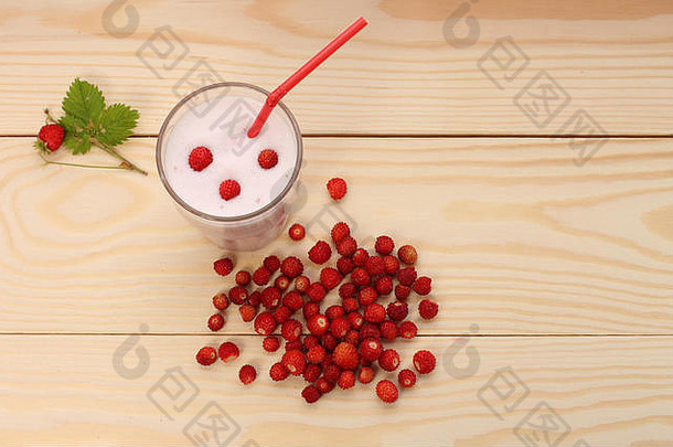 将野生<strong>草莓</strong>装在玻璃杯中，将野生<strong>草莓</strong>放在木桌上，制成冰沙。