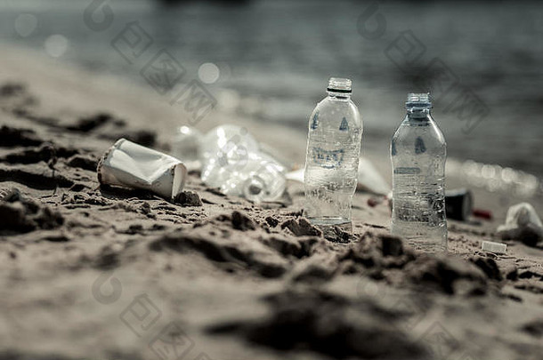 不负责任的人在河边留下的空塑料瓶的特写