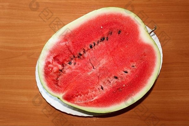 一个成熟的西瓜被切下来放在一个大的白色盘子上。