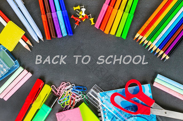 在黑板上贴上五颜六色的学校用品，上面写着返回学校的文字。教育观念。