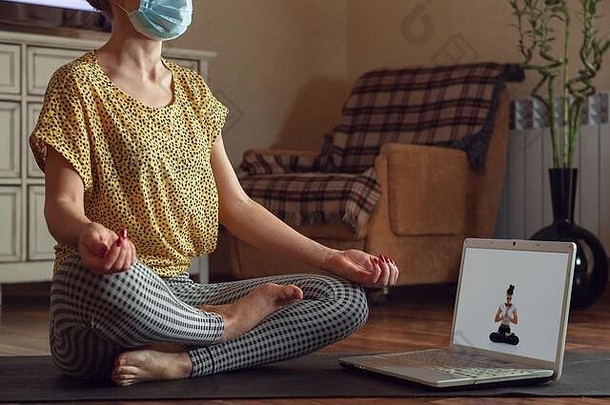 运动年轻的女人采取瑜伽教训在线实践首页检疫概念健康的生活方式健康安全冠状病毒流感大流行爱好