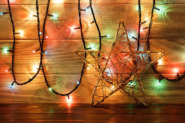 木制桌子上有星星和灯光的复古圣诞装饰。