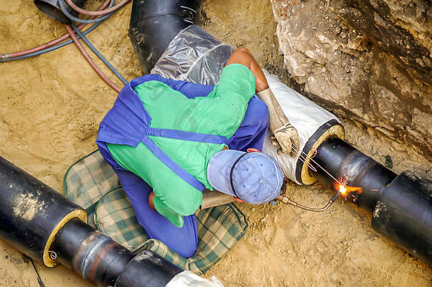 焊工在地沟内焊接加热管道