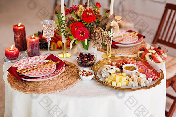 豪华的餐桌设置，配有蜡烛和玻璃器皿，美丽的模糊背景。参加活动、婚礼。在阁楼内部为假日或浪漫之夜做准备