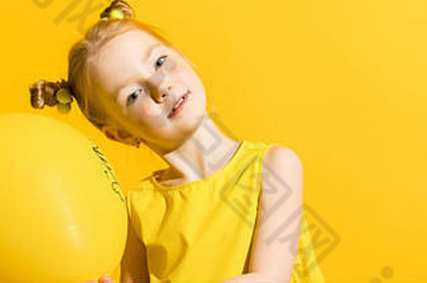 黄底红头发的女孩。那个女孩双手捧着一个黄色的气球。