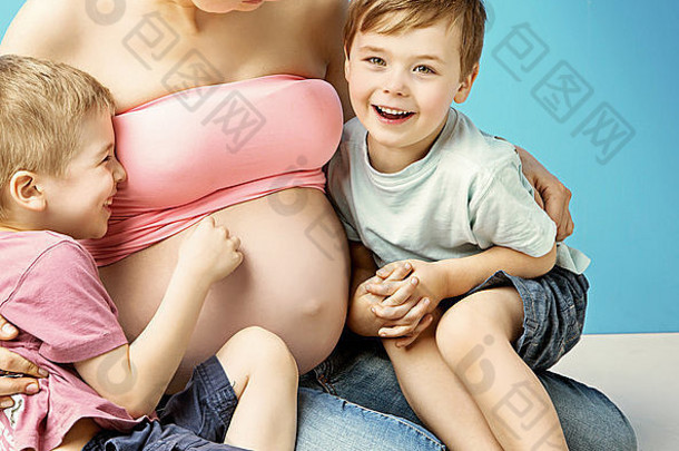 体贴的怀孕母亲拥抱着她可爱的儿子