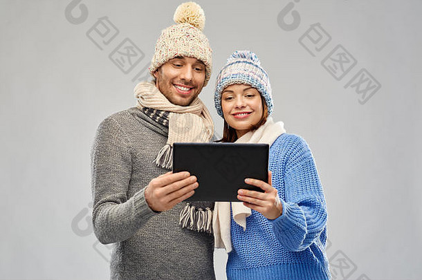 一对穿着冬装的情侣用平板电脑