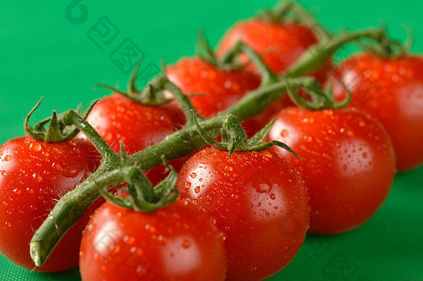 绿色砧板上显示的葡萄藤上的西红柿，是食品卫生的正确颜色