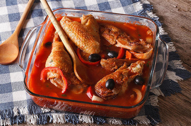 在玻璃碗里用番茄酱、橄榄和胡椒炖成的鸡块特写镜头。水平的