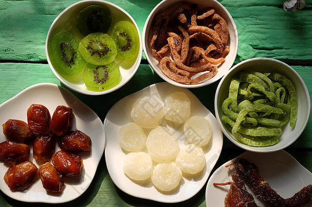 绿色背景的越南春节五彩越南果酱、亚洲农历新年、传统猕猴桃果脯、丹森果酱、椰子果酱
