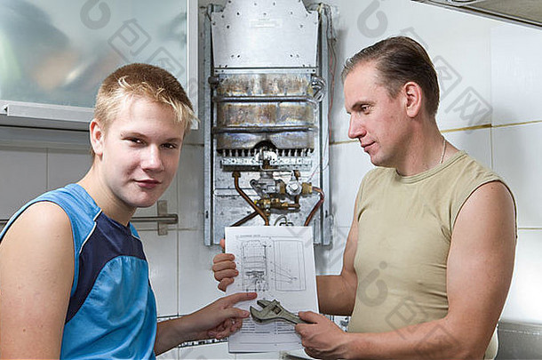 家庭中关系的概念。父亲和儿子一起看修理燃气热水器的说明书