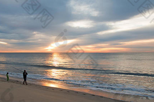 父亲和女儿在日出时分在墨西哥下加利福尼亚州圣何塞德尔卡波海滩钓鱼