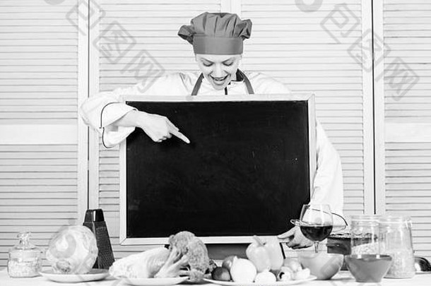 你的产品在这里。厨师大师在烹饪课上做了一些介绍。漂亮女人用手指着黑板。厨师长在烹饪学校任教。烹饪学校的硕士班，空间。