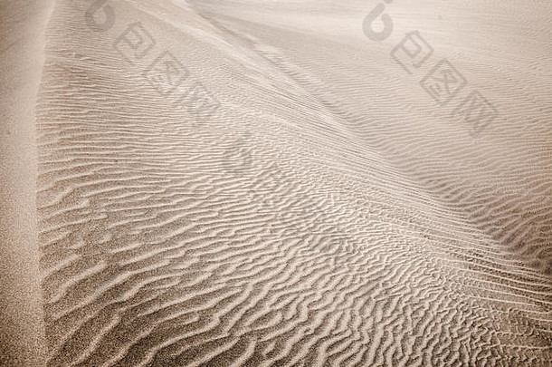沙丘表面的沙和风模式。图案由两种类型的<strong>沙粒</strong>组成-深色、小而轻和大而轻和重