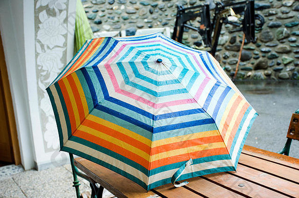五颜六色美丽的雨伞雨淋在桌子上，而在室外下雨