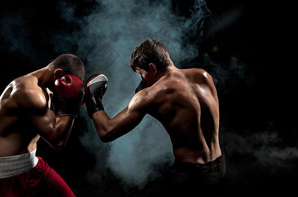两名职业拳击手在黑烟背景下拳击，