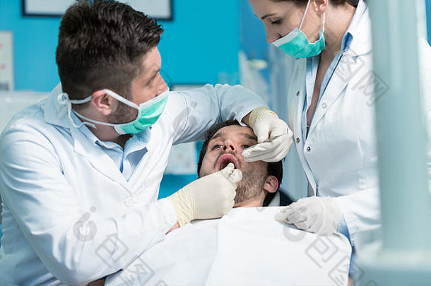 牙科教育。男牙医-医生-教师讲解治疗程序。