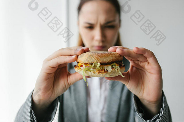 一个年轻女孩表示她不喜欢汉堡。拒绝不健康饮食的概念形象。