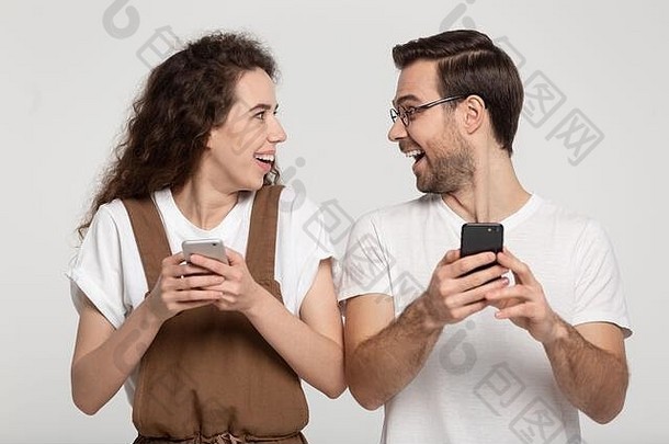 兴奋惊讶年轻的夫妇持有手机