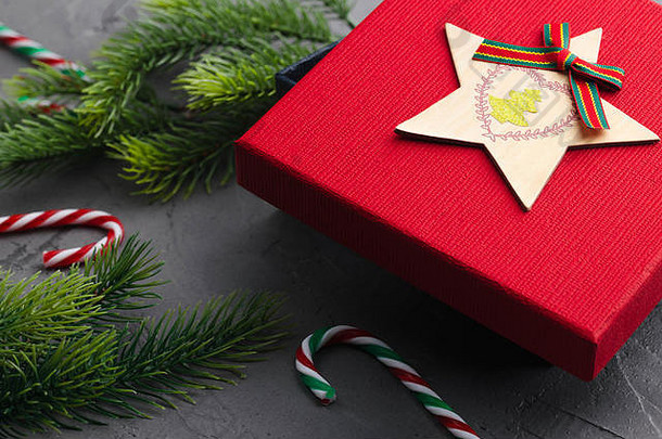 混凝土灰色背景上的杉木树枝，带有红色礼品盒和装饰品。圣诞节和新年。平铺。