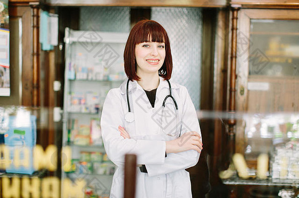 一位美丽的药剂师在药店愉快地对着镜头微笑的水平肖像。