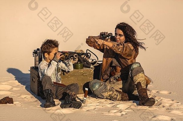 帖子世界末日英雄女人男孩双筒望远镜在户外沙漠死荒地背景英雄女孩战士破旧的衣服孩子坐着营查看望远镜夫妇人搜索核出奇地时间生活世界末日概念