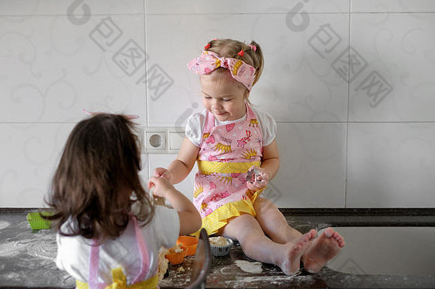 两个小女孩在家的厨房里做饼干