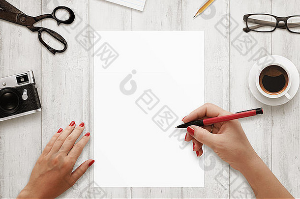 女人写红色的笔孤立的<strong>白色</strong>纸咖啡眼镜相机记事本铅笔木表格前视图