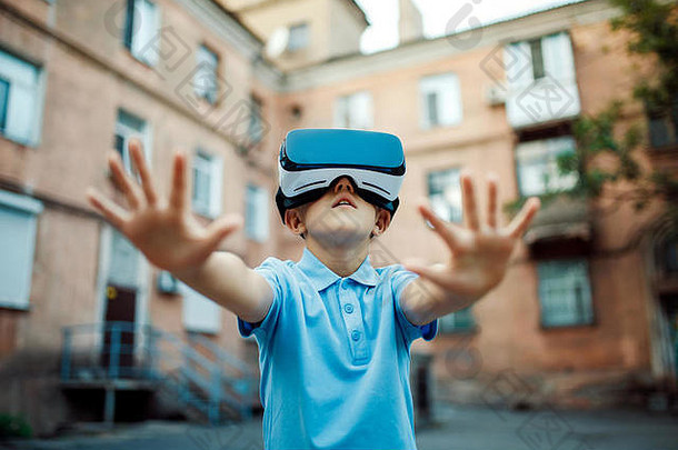 使用VR虚拟现实护目镜迷住了小男孩。户外的